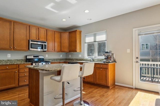 2707 Amber Crest Rd, Hanover, MD 21076 - kitchen featuring appliances with stainless steel finishes, light wood-style flooring, brown cabinetry, light stone countertops, and recessed lighting
