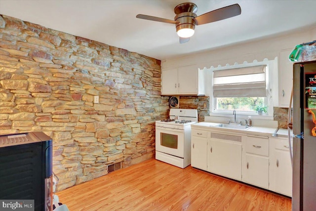 30 N Dwight St, Reading, PA 19609 - kitchen with white gas range oven, light countertops, white cabinetry, freestanding refrigerator, and light wood-type flooring