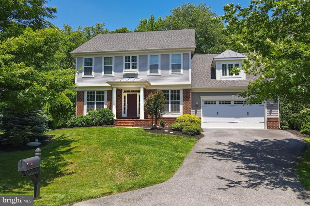 1413 Triton Ct, Edgewater, MD 21037 - colonial house with brick siding, asphalt driveway, a front yard, and a garage