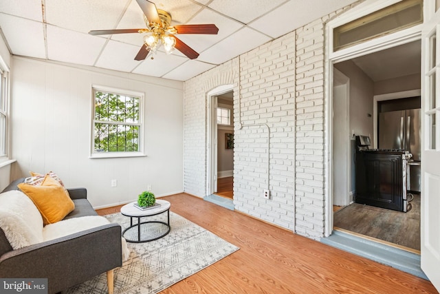 1818 Newton St NE, Washington, DC 20018 - sitting room with a ceiling fan, wood finished floors, a drop ceiling, brick wall, and arched walkways