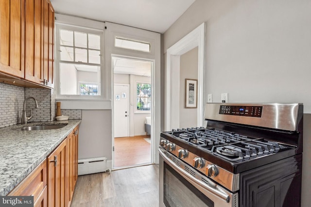 1818 Newton St NE, Washington, DC 20018 - kitchen featuring stainless steel gas range, baseboard heating, decorative backsplash, light wood-style flooring, and light stone countertops