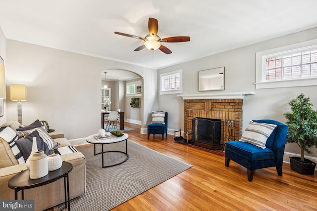 1818 Newton St NE, Washington, DC 20018 - living area with wood finished floors, arched walkways, a ceiling fan, a brick fireplace, and ornamental molding