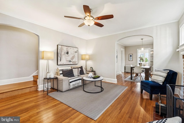 1818 Newton St NE, Washington, DC 20018 - living area featuring arched walkways, radiator, wood finished floors, ceiling fan, and crown molding