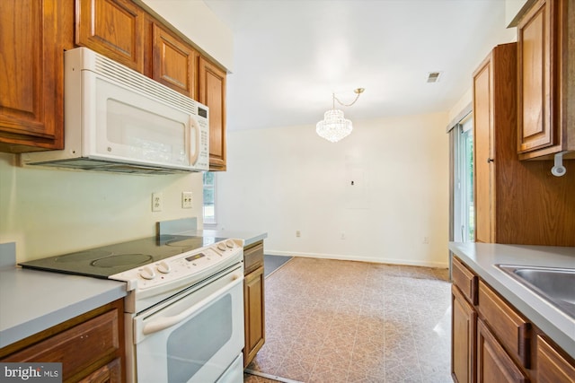 14050 Oaks Rd, Hughesville, MD 20637 - kitchen featuring white appliances, healthy amount of natural light, and brown cabinets