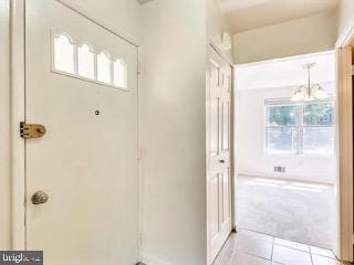5005 Berwyn Rd, College Park, MD 20740 - doorway with healthy amount of natural light, light tile patterned floors, light carpet, and a chandelier