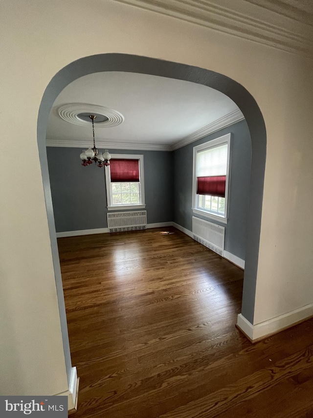257 Jefferson St, Winchester, VA 22601 - unfurnished room featuring radiator, ornamental molding, arched walkways, a chandelier, and wood finished floors