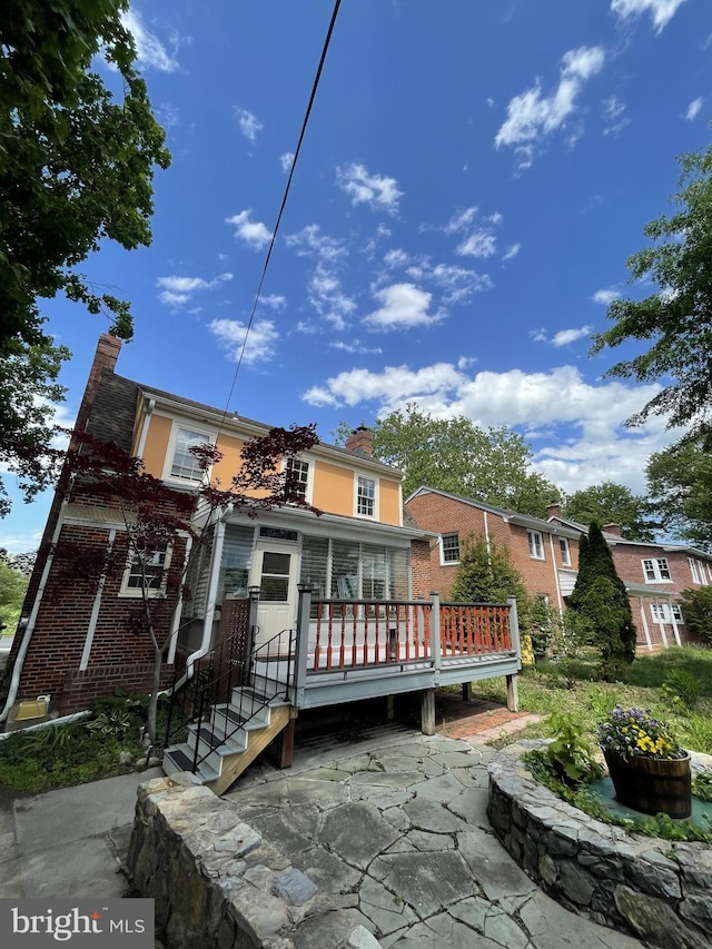 257 Jefferson St, Winchester, VA 22601 - rear view of property with a chimney, brick siding, and a wooden deck