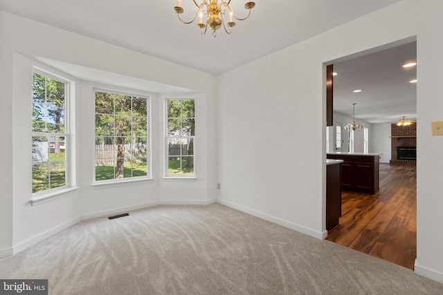 27 Brown Cir, Fredericksburg, VA 22405 - unfurnished room featuring a chandelier, healthy amount of natural light, carpet floors, a brick fireplace, and recessed lighting