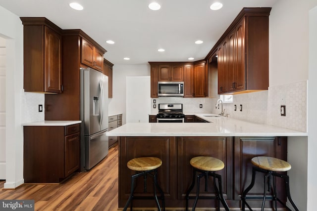 27 Brown Cir, Fredericksburg, VA 22405 - kitchen featuring appliances with stainless steel finishes, a peninsula, wood finished floors, light countertops, and recessed lighting