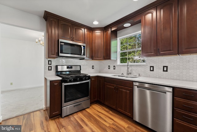 27 Brown Cir, Fredericksburg, VA 22405 - kitchen with stainless steel appliances, light wood-style flooring, a chandelier, tasteful backsplash, and dark brown cabinetry