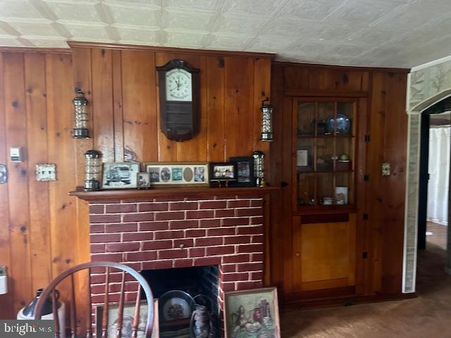 2012 E Main St, Douglassville, PA 19518 - kitchen with a fireplace, wooden walls, brown cabinetry, ornamental molding, and an ornate ceiling