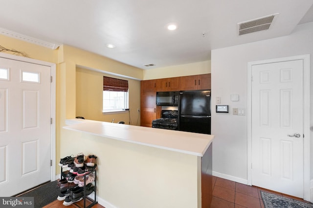 6221 Sandpiper Ct Unit 7, Elkridge, MD 21075 - kitchen with black appliances, a peninsula, dark tile patterned floors, recessed lighting, and brown cabinetry