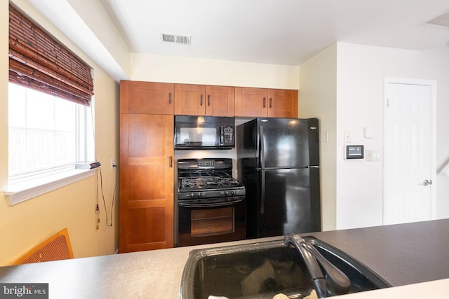6221 Sandpiper Ct Unit 7, Elkridge, MD 21075 - kitchen with black appliances, an office area, and brown cabinets
