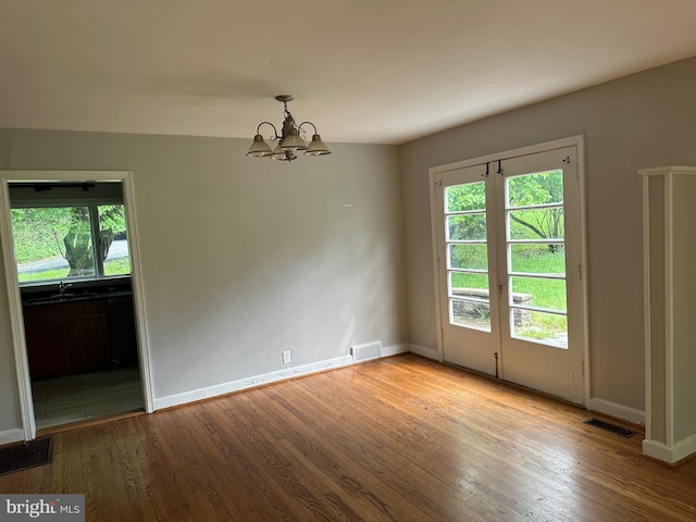 769 S Water St, Woodstock, VA 22664 - unfurnished room with wood finished floors, a chandelier, and healthy amount of natural light