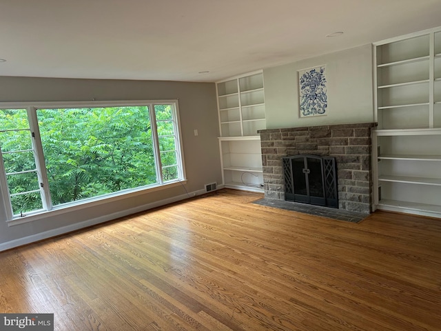 769 S Water St, Woodstock, VA 22664 - unfurnished living room with wood finished floors, built in features, and a fireplace with flush hearth