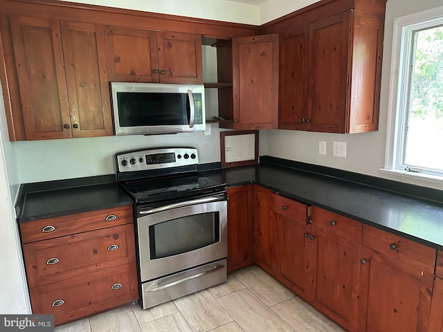 769 S Water St, Woodstock, VA 22664 - kitchen with stainless steel appliances, dark countertops, and brown cabinets