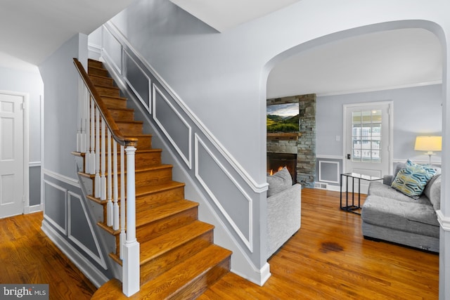 4 Haslet Way, Wilmington, DE 19807 - stairs featuring arched walkways, wood finished floors, wainscoting, a fireplace, and a decorative wall