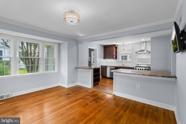 4 Haslet Way, Wilmington, DE 19807 - kitchen with wall chimney range hood, a peninsula, wood-type flooring, stainless steel dishwasher, and ornamental molding