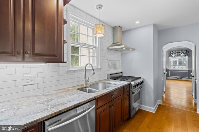 4 Haslet Way, Wilmington, DE 19807 - kitchen with wall chimney exhaust hood, appliances with stainless steel finishes, light wood finished floors, tasteful backsplash, and light stone countertops