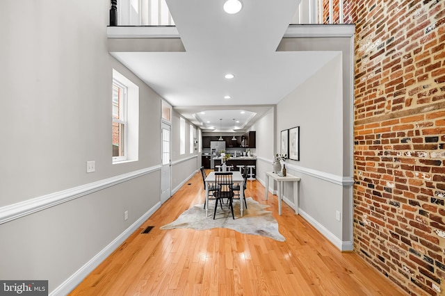 1717 Bank St, Baltimore, MD 21231 - dining room featuring brick wall, light wood-style floors, and recessed lighting
