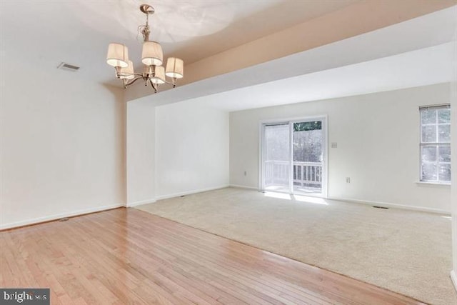 15246 Streamside Ct, Dumfries, VA 22025 - empty room featuring a chandelier, wood finished floors, and carpet flooring