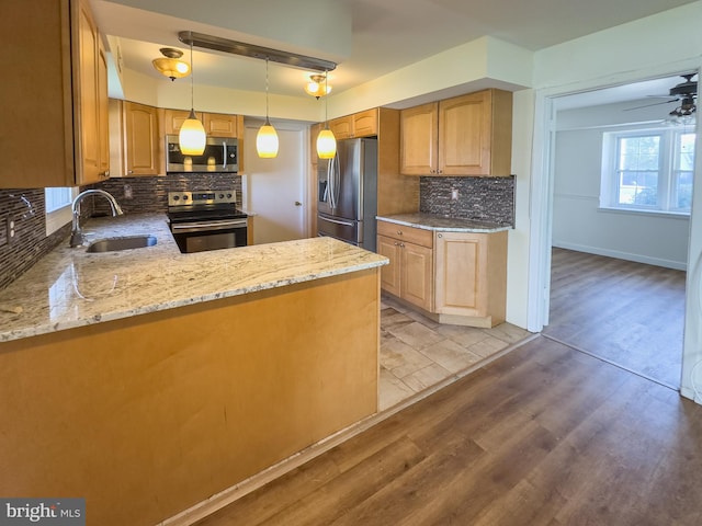35 Gentry Ln, Willingboro, NJ 08046 - kitchen featuring stainless steel appliances, light stone counters, tasteful backsplash, light wood finished floors, and decorative light fixtures