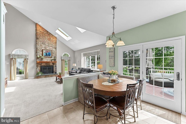 4 William Howard Dr, Glen Mills, PA 19342 - dining space featuring a skylight, a fireplace, high vaulted ceiling, light tile patterned floors, and light colored carpet