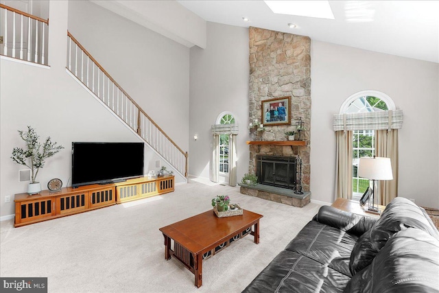 4 William Howard Dr, Glen Mills, PA 19342 - carpeted living room with high vaulted ceiling, stairs, healthy amount of natural light, a stone fireplace, and a skylight