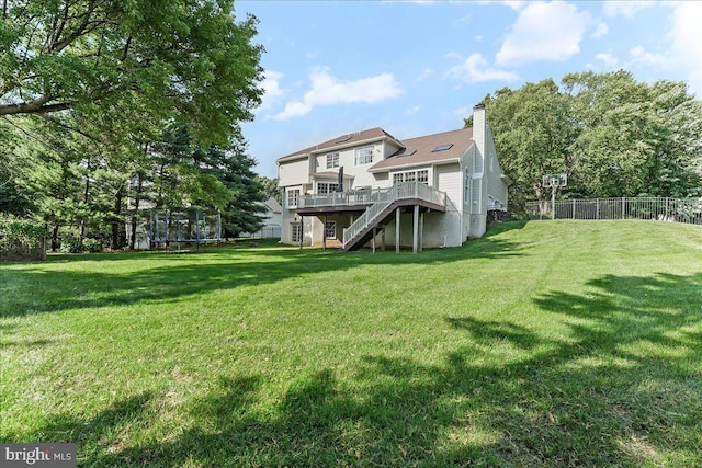 4 William Howard Dr, Glen Mills, PA 19342 - back of property featuring a trampoline, stairway, a wooden deck, and a chimney