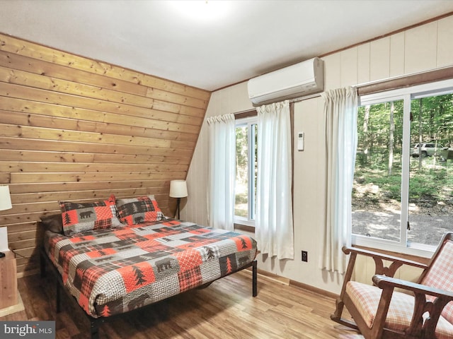 13 Mountainside Dr, Berkeley Springs, WV 25411 - bedroom featuring a wall mounted AC, light wood-style flooring, and wooden walls
