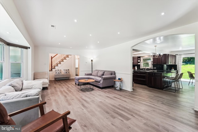 12116 Long Ridge Ln, Bowie, MD 20715 - living room featuring arched walkways, light wood finished floors, stairway, a chandelier, and recessed lighting