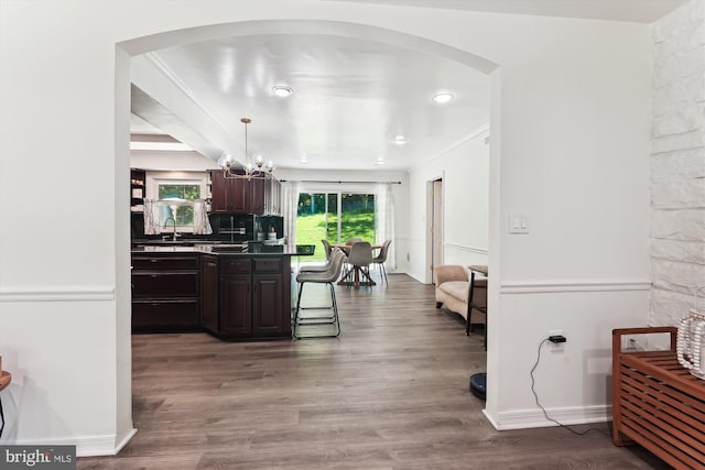 12116 Long Ridge Ln, Bowie, MD 20715 - kitchen featuring arched walkways, a chandelier, dark brown cabinetry, dark countertops, and wood finished floors