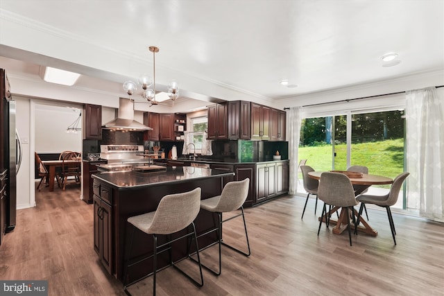 12116 Long Ridge Ln, Bowie, MD 20715 - kitchen featuring wall chimney range hood, dark countertops, a chandelier, crown molding, and decorative backsplash