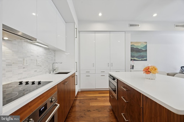 621 S 24th St Unit 204, Philadelphia, PA 19146 - kitchen with modern cabinets, stainless steel appliances, white cabinets, a kitchen island, and dark wood-style flooring