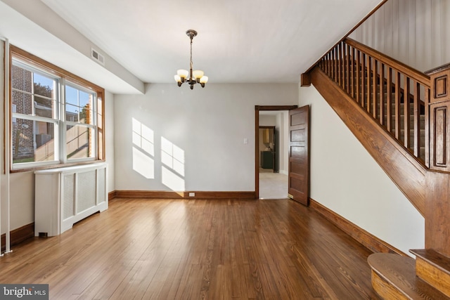 313 W 5th Ave, Conshohocken, PA 19428 - unfurnished living room with radiator, stairs, a chandelier, and hardwood / wood-style flooring