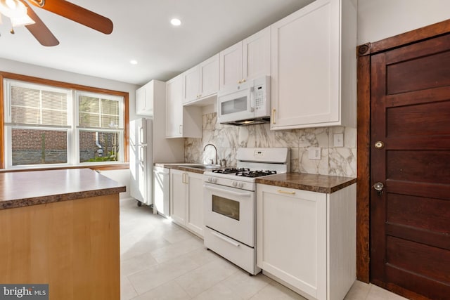 313 W 5th Ave, Conshohocken, PA 19428 - kitchen featuring white appliances, backsplash, dark countertops, ceiling fan, and white cabinets