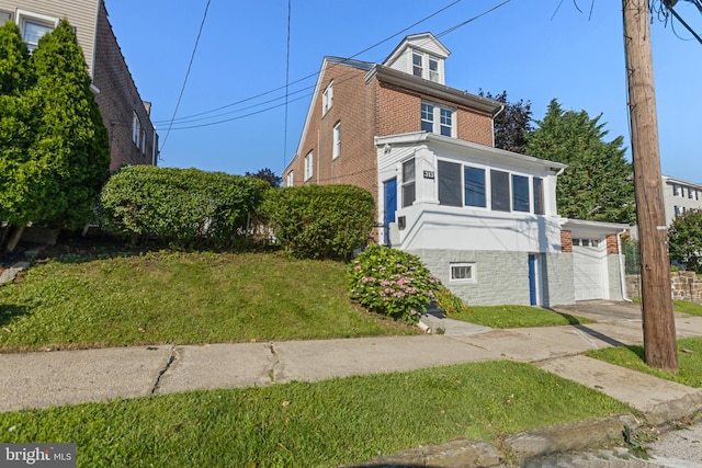 313 W 5th Ave, Conshohocken, PA 19428 - view of front facade with brick siding, a garage, a front yard, and driveway