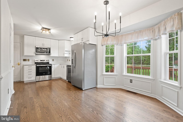 14057 Broadview Ln, Culpeper, VA 22701 - kitchen with appliances with stainless steel finishes, a chandelier, dark wood-type flooring, light countertops, and white cabinetry