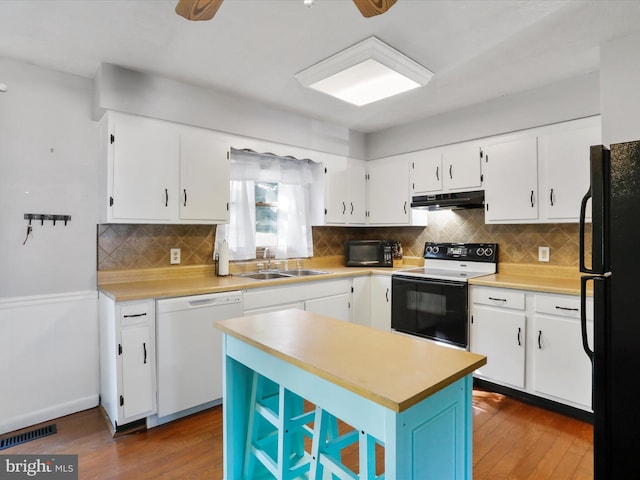 674 Harrison Ave, Berkeley Springs, WV 25411 - kitchen featuring black appliances, under cabinet range hood, light countertops, and white cabinetry