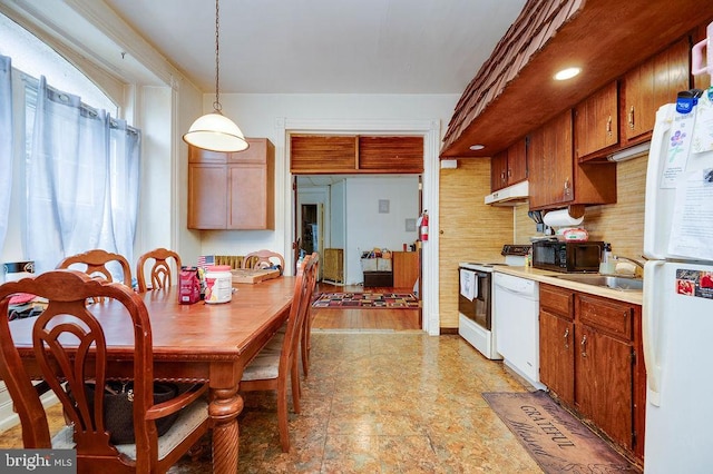 1407 Hill Rd, Reading, PA 19602 - kitchen with white appliances, under cabinet range hood, light countertops, decorative light fixtures, and backsplash