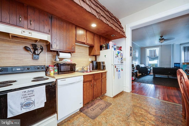 1407 Hill Rd, Reading, PA 19602 - kitchen featuring white appliances, under cabinet range hood, light countertops, decorative backsplash, and brown cabinetry