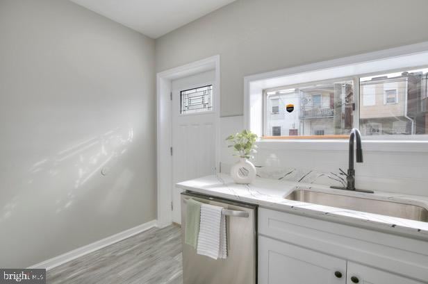 429 N Lakewood Ave, Baltimore, MD 21224 - kitchen featuring dishwasher, light wood-style floors, white cabinets, and light stone countertops