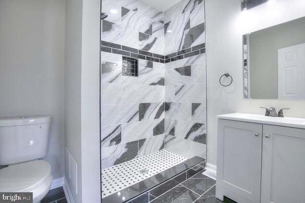 429 N Lakewood Ave, Baltimore, MD 21224 - bathroom with tiled shower, vanity, and marble finish flooring