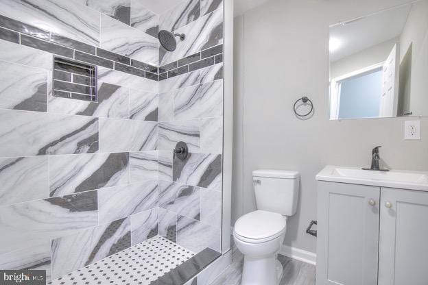 429 N Lakewood Ave, Baltimore, MD 21224 - full bathroom with a tile shower, vanity, and wood finished floors