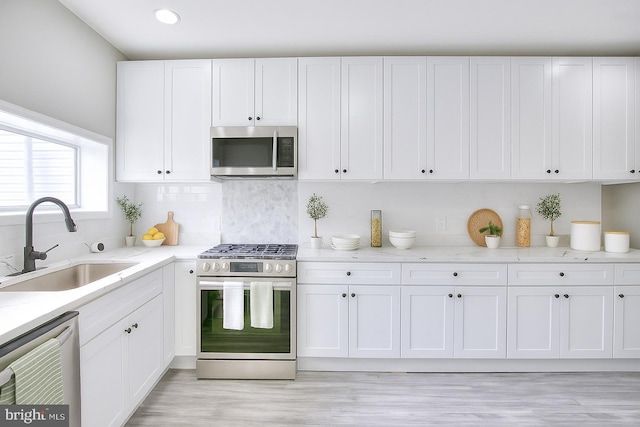 429 N Lakewood Ave, Baltimore, MD 21224 - kitchen with stainless steel appliances, white cabinets, light stone countertops, light wood-type flooring, and recessed lighting