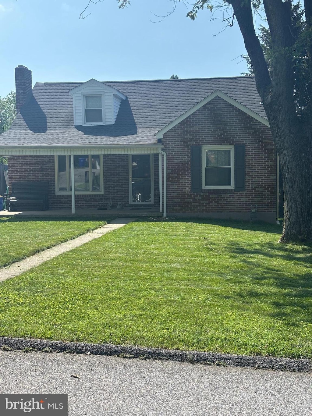 404 Corbin Rd, York, PA 17403 - view of front of home with brick siding, a front lawn, and a chimney