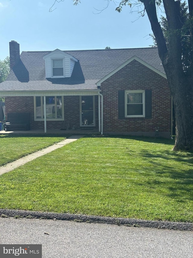 404 Corbin Rd, York, PA 17403 - view of front of home with brick siding, a front lawn, and a chimney