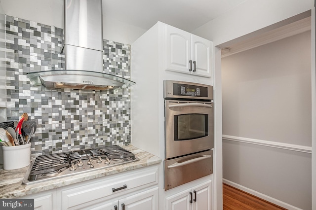 9016 Greylock St, Alexandria, VA 22308 - kitchen with appliances with stainless steel finishes, a warming drawer, wall chimney range hood, backsplash, and white cabinets