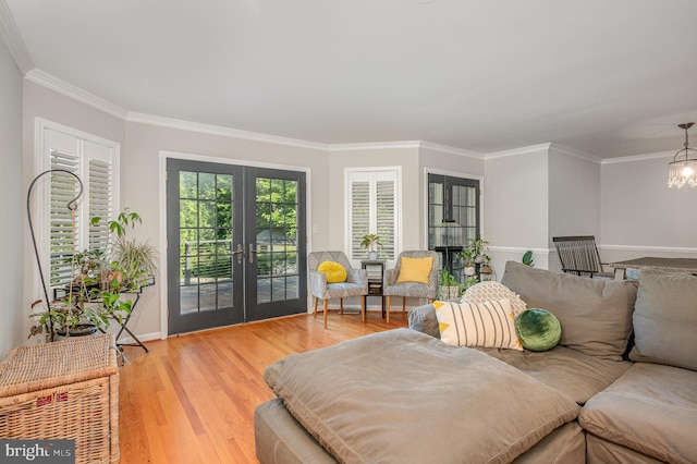 9016 Greylock St, Alexandria, VA 22308 - living room with french doors, light wood-type flooring, a chandelier, and crown molding