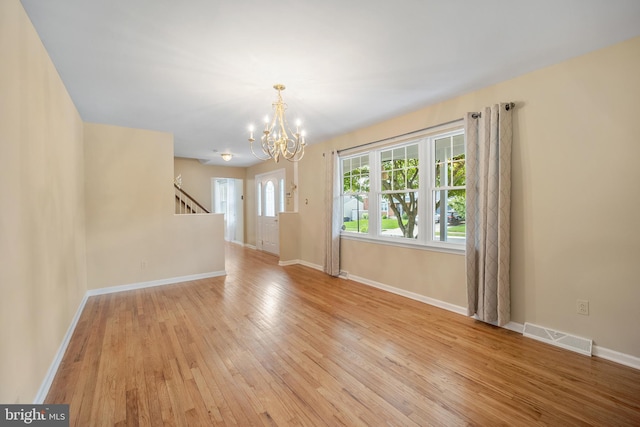 510 Revere Ct, Hockessin, DE 19707 - empty room with a chandelier, light wood-style floors, and stairs